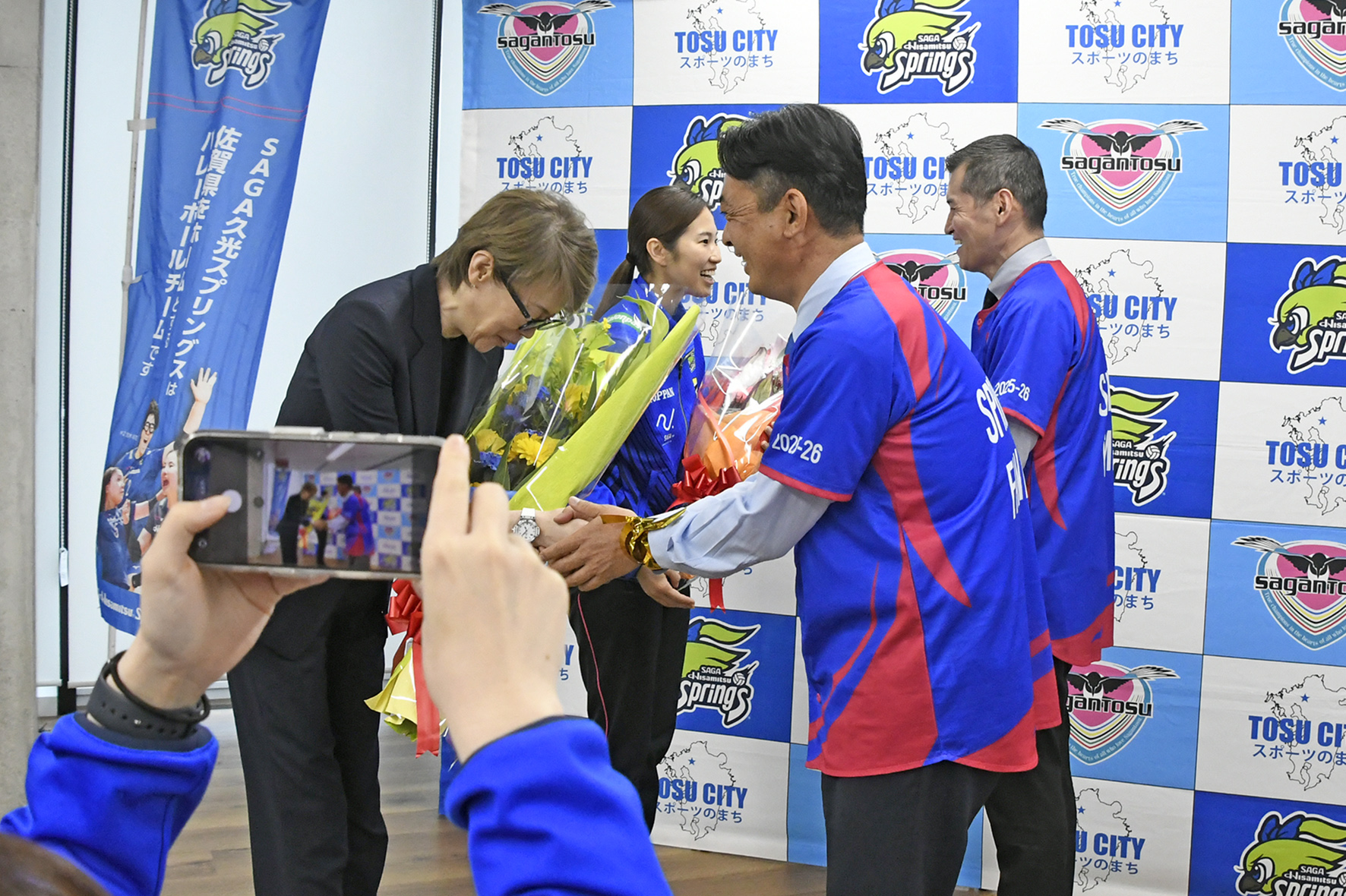 中田久美ヘッドコーチに花束を渡す向門市長と栄キャプテンに花束を渡す松隈議長
